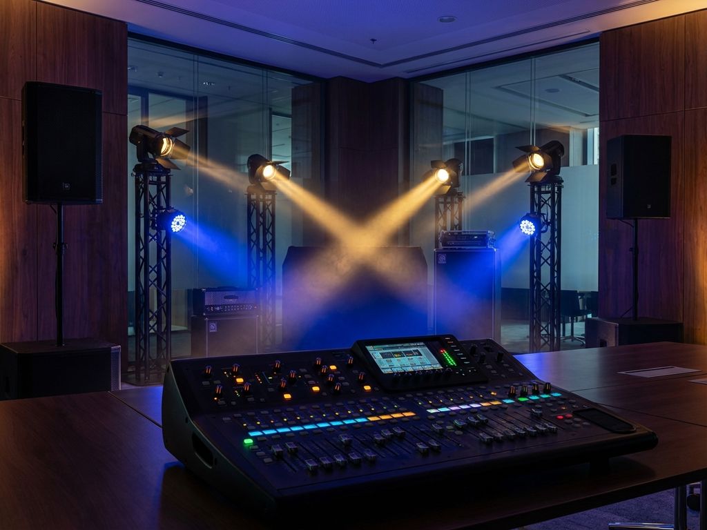 Professionele geluids- en verlichtingsapparatuur met mengpaneel en podiumlampen in moderne evenementenruimte