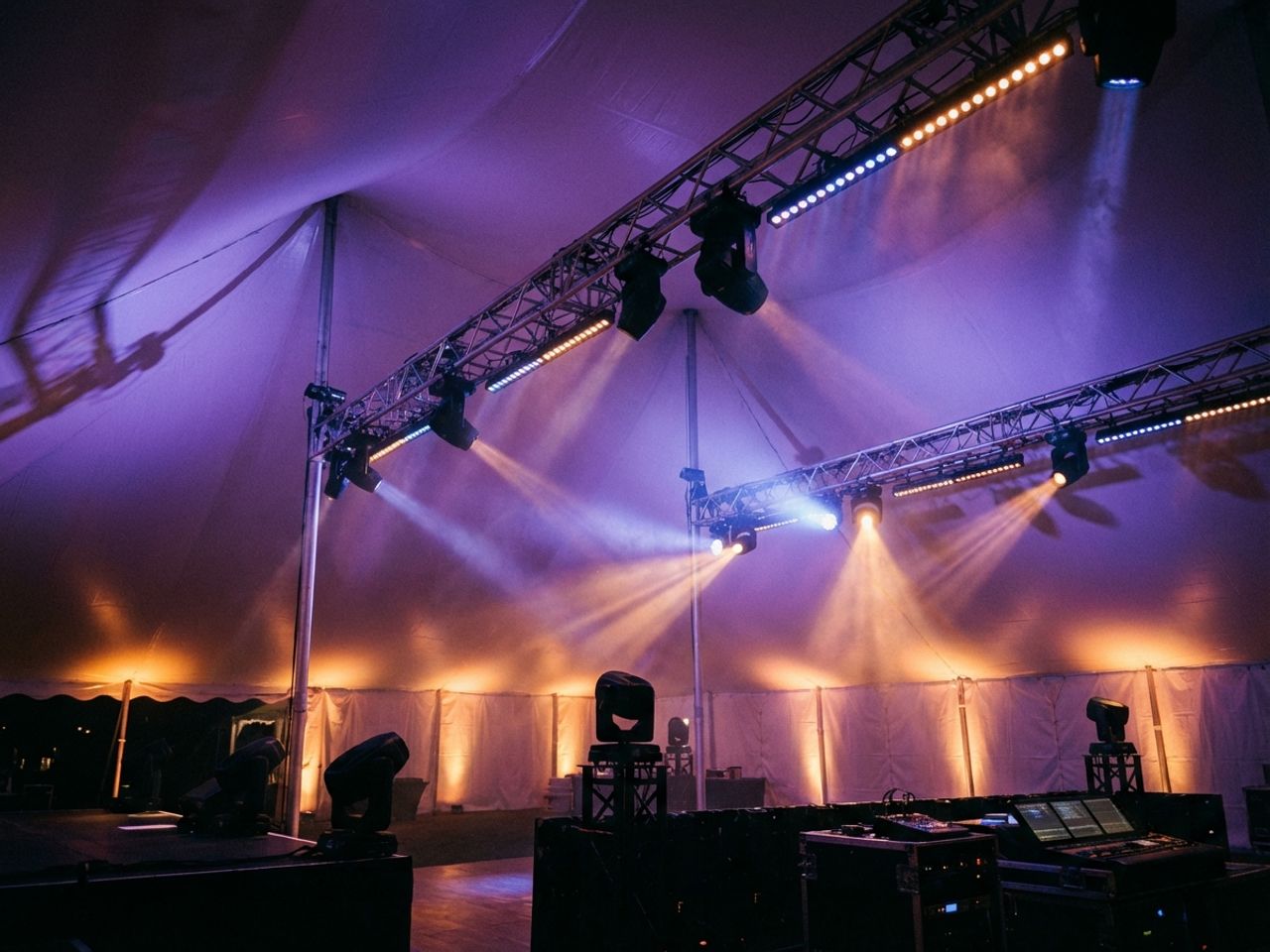 Professionele LED-verlichting met paarse, blauwe en amberkleurige lichtstralen in witte eventtent 's nachts
